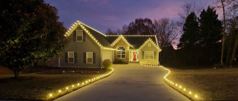 Lights along a wide roofline at dusk, the roofline look our Christmas light packages start with One of our holiday packages.