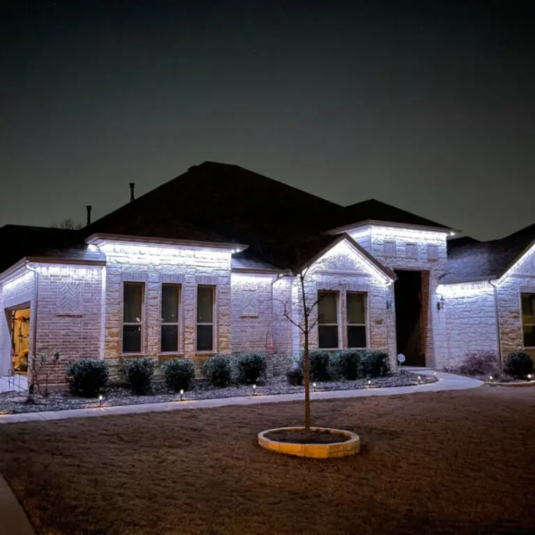 White permanent lights along the roofline of a single-story stone home