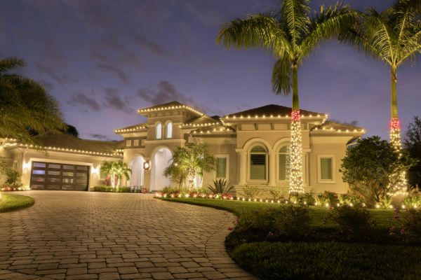 Christmas light installation in Celebration FL featuring warm white roofline and palm tree lighting