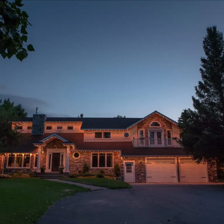 Warm white permanent lighting on a roofline at dusk