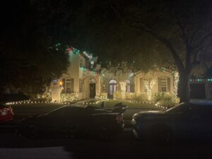 Professional Christmas light installation on Mediterranean-style Orlando home featuring red and green C9 roofline lights, warm white wrapped trees, and illuminated landscape lighting