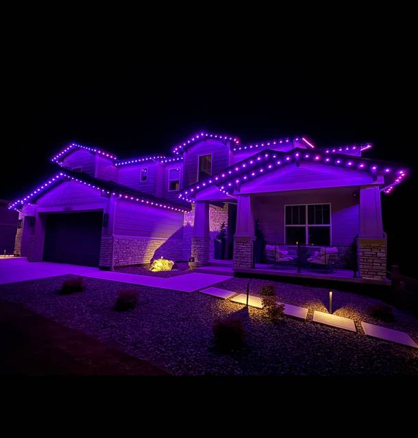 Purple permanent lights along the rooflines of a single-story home