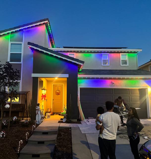 Multicolor permanent lights on a two-story home at dusk
